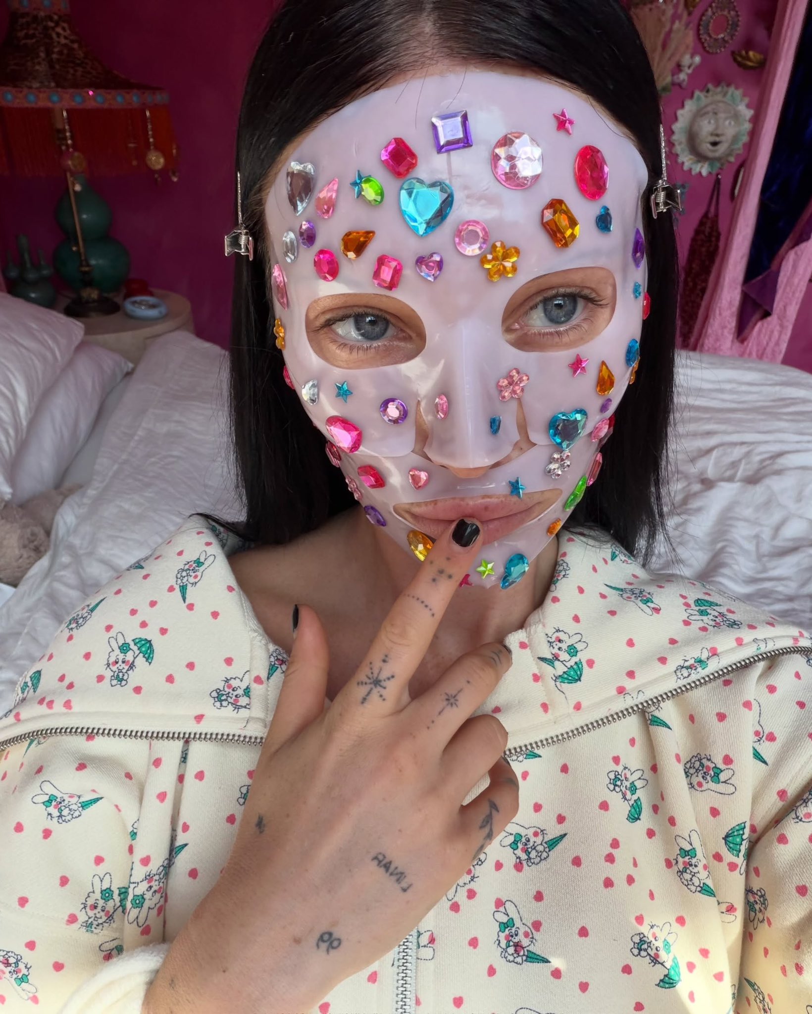 person wearing a face mask covered in colorful gems